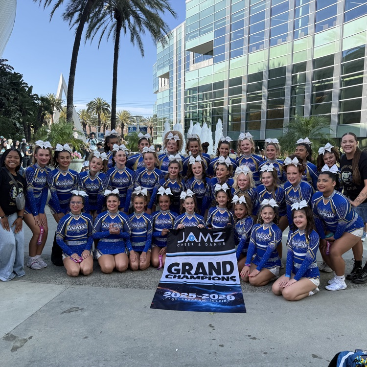 group of cheerleaders with grand champion banner