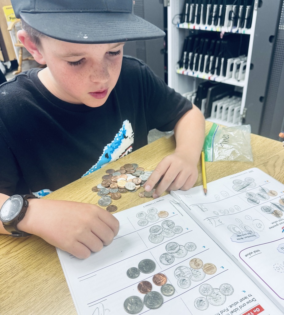 student using coins to solve problems in math book