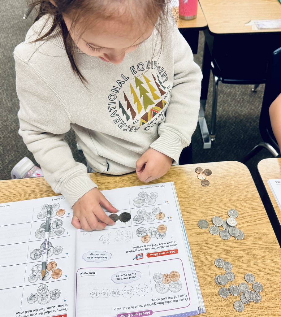 student using coins to solve problems in math book
