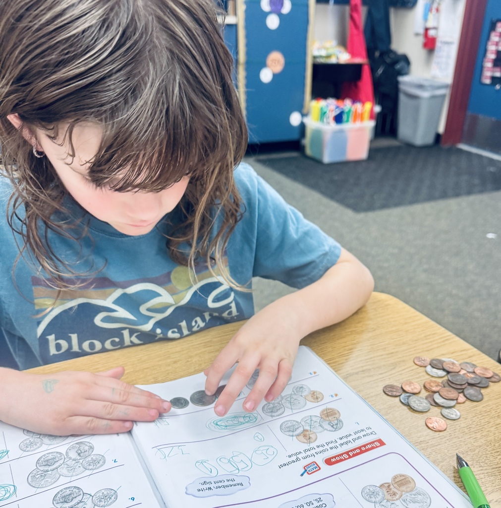 student using coins to solve problems in math book