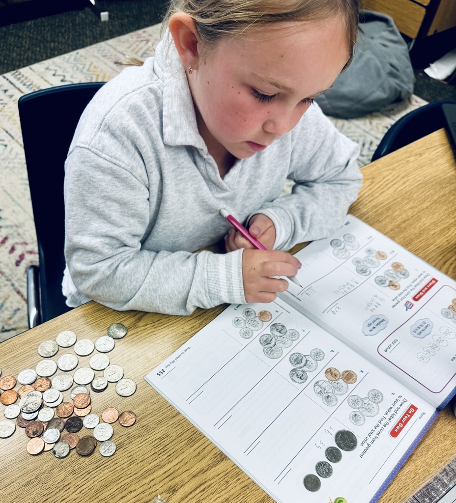 student using coins to solve problems in math book