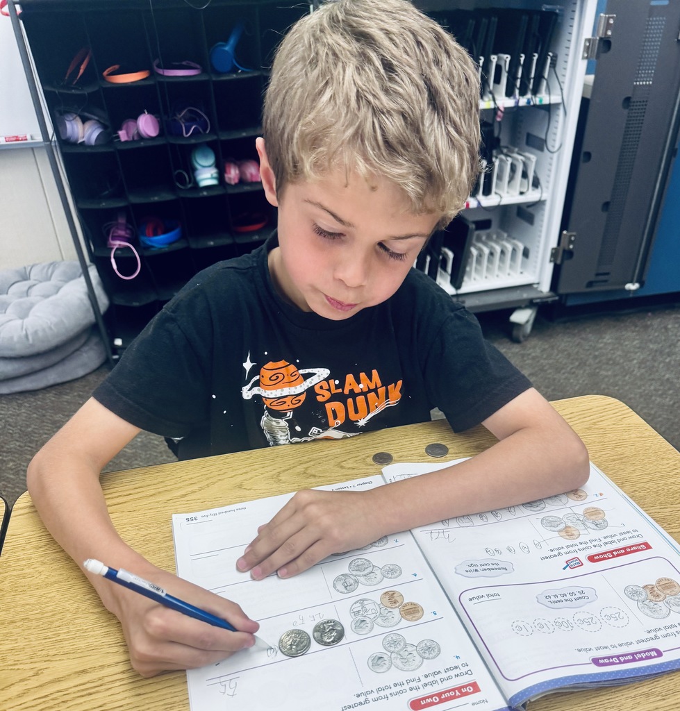 student using coins to solve problems in math book