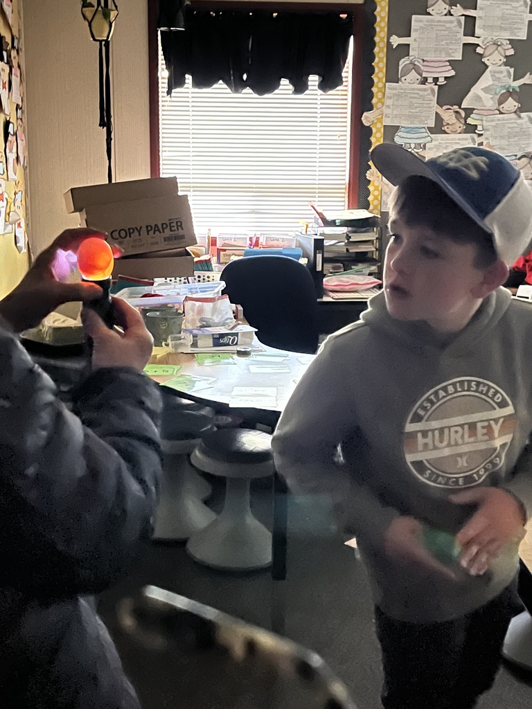 student looking at an egg with a flashlight