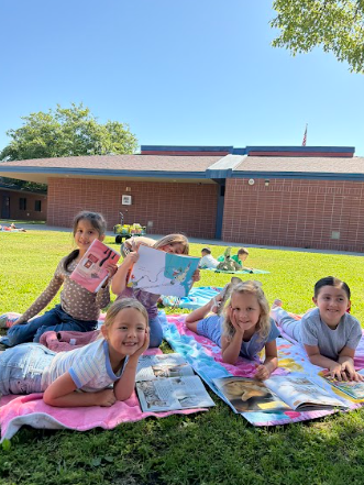 students reading books laying on beach towels