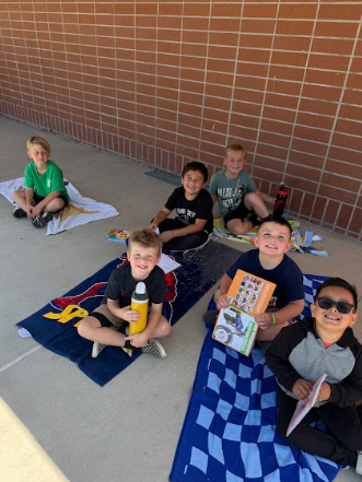 students reading books laying on beach towels