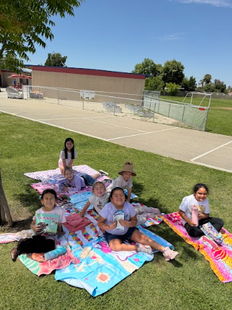 students reading books laying on beach towels