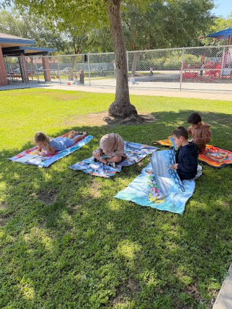 students reading books laying on beach towels