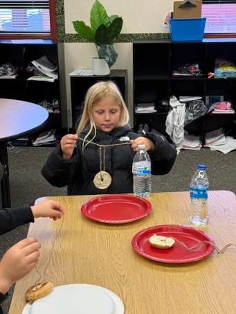 students with bagels string and red plates