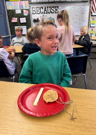 student with bagels string and red plates