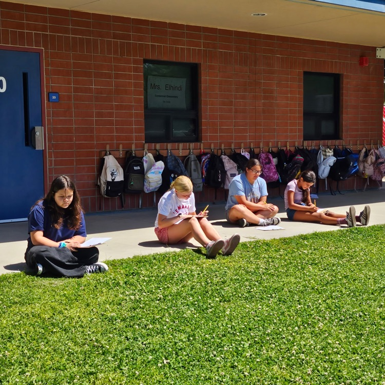 kids siting outside writing