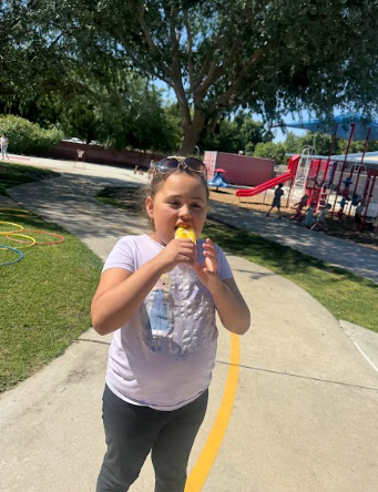 student eating a popsicle at a table