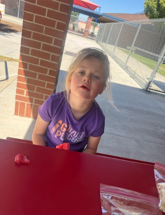 student eating a popsicle at a table