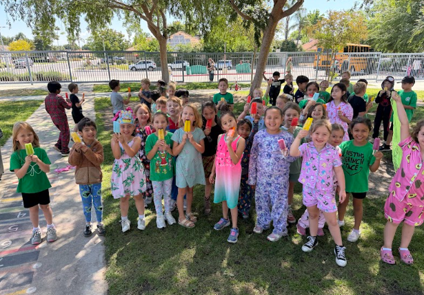 students with popsicles wearing pajamas on the playground