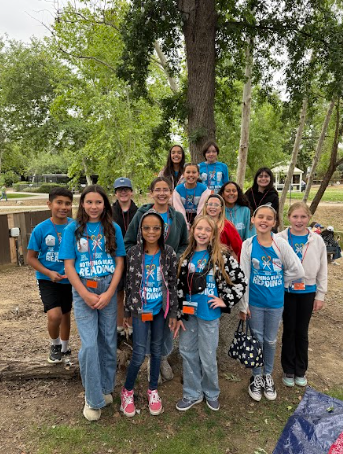 students wearing matching shirts gathered under a tree