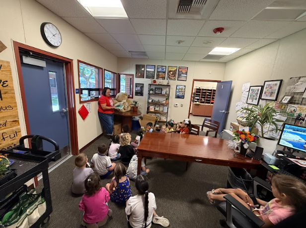 students in the principal's office listening to a story