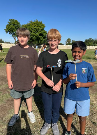 students holding a butterfly puppet