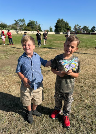 students holding a butterfly puppet