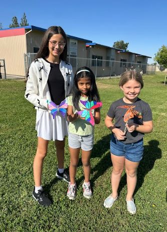 students holding a butterfly puppet