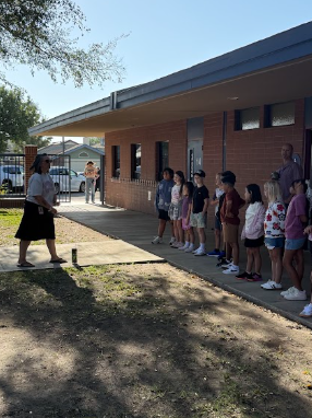 students gathered around adult listening to behavior expectations