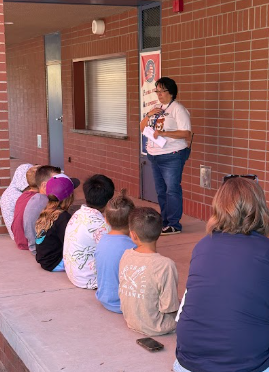 students gathered around adult listening to behavior expectations