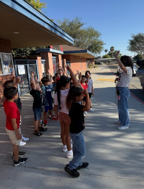 students gathered around adult listening to behavior expectations