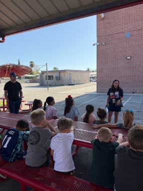 students gathered around adult listening to behavior expectations