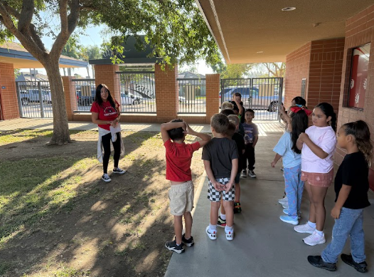 students gathered around adult listening to behavior expectations