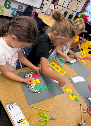 students working on math posters apples