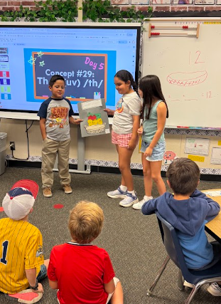 students presenting apple math posters