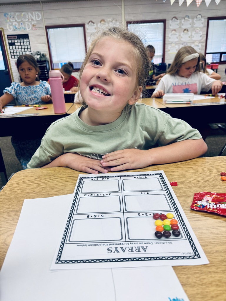 student at desk working with skittles and math arrays