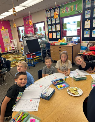 students at desks with apples