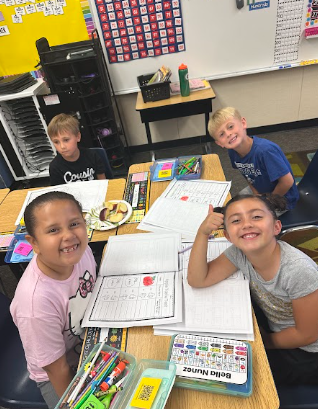students at desks with apples