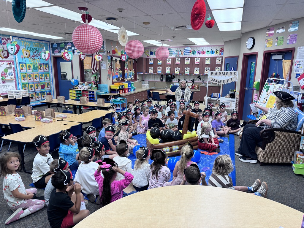students wearing pirate hats listening to a story