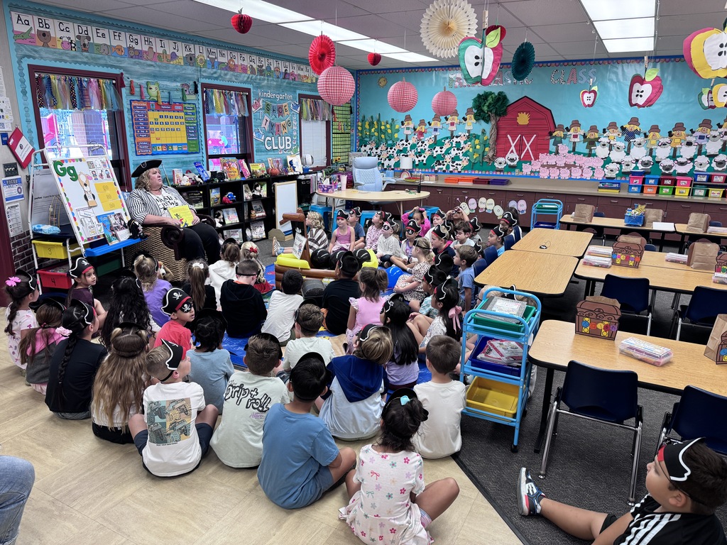students wearing pirate hats listening to a story