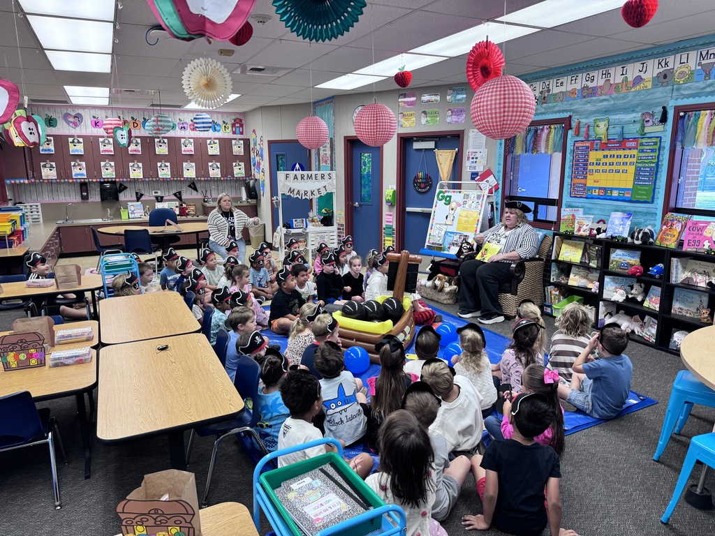 students wearing pirate hats listening to a story