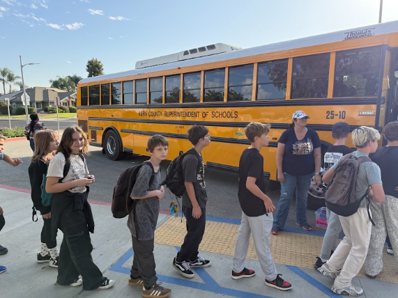 students gathered outside a bus getting ready to leave for camp