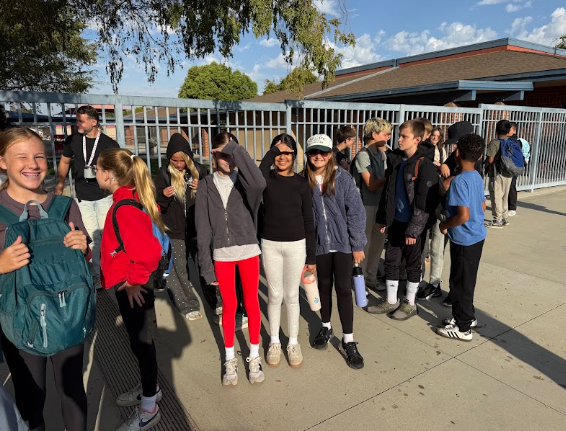 students gathered outside a bus getting ready to leave for camp