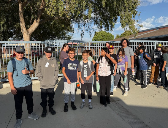 students gathered outside a bus getting ready to leave for camp