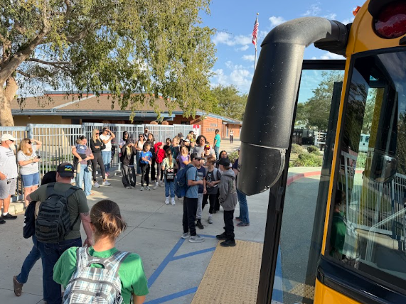 students gathered outside a bus getting ready to leave for camp