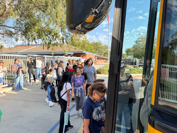 students gathered outside a bus getting ready to leave for camp