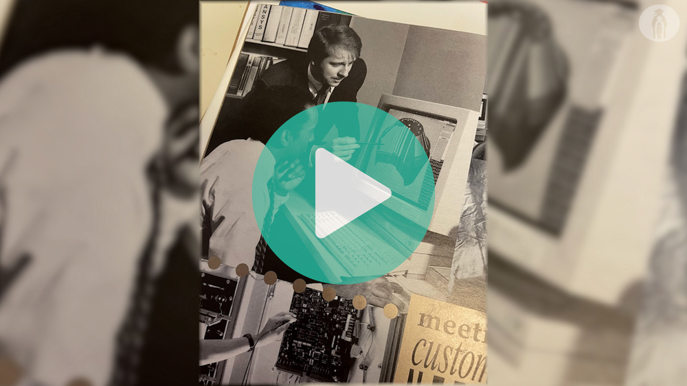 Old black and white picture of Joseph Ivanenok looking at a computer with a coworker.