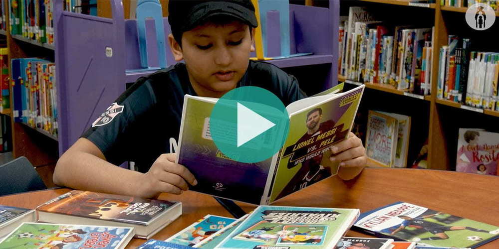 student reading book about soccer