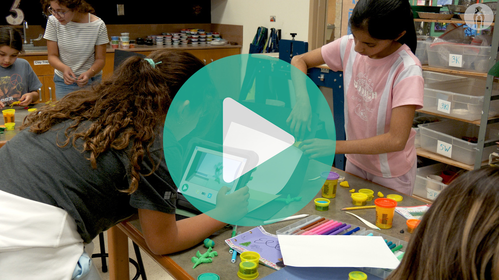 Students in the art room working with iPads shooting stop motion videos