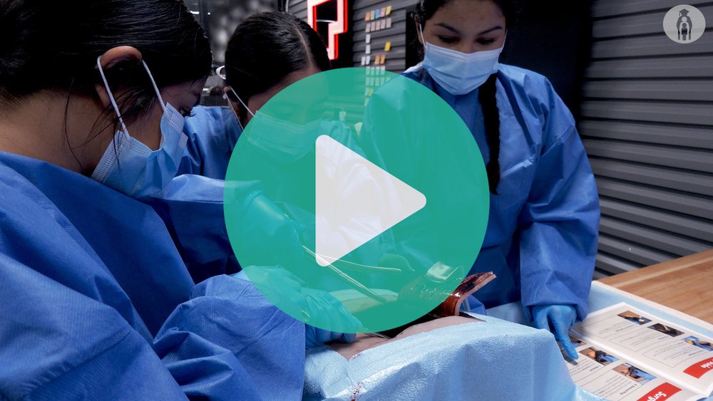 Picture of Round Rock ISD P-TECH students performing practice surgery on a dummy. 