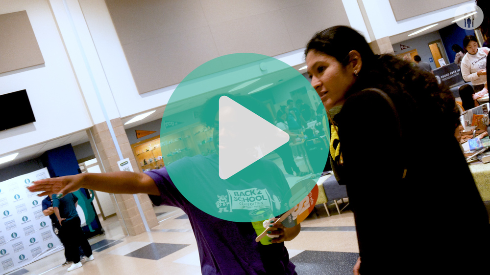 Picture of Round Rock ISD employee pointing the way to enrollment area.