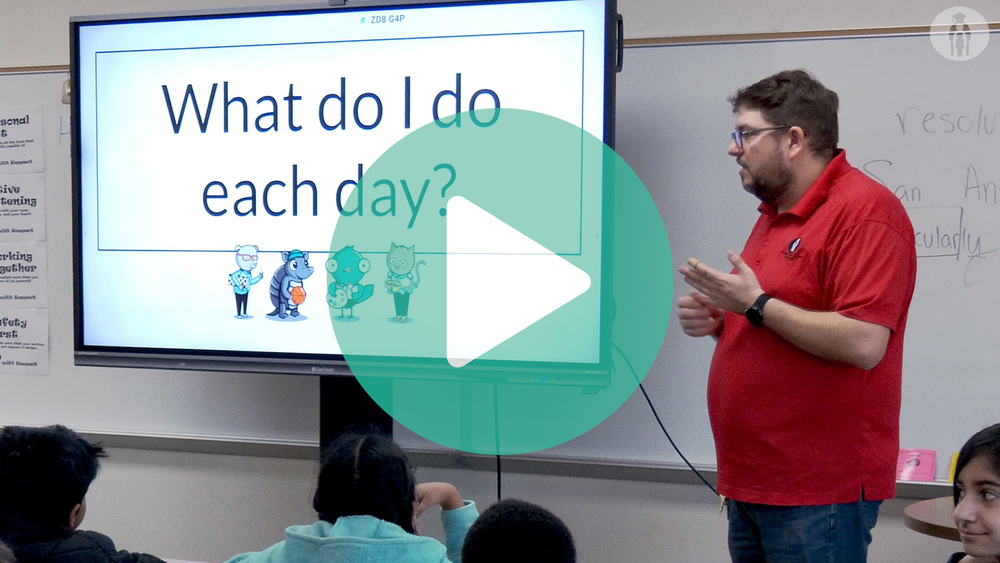 Picture of volunteer adult standing in front of the class talking about his career.