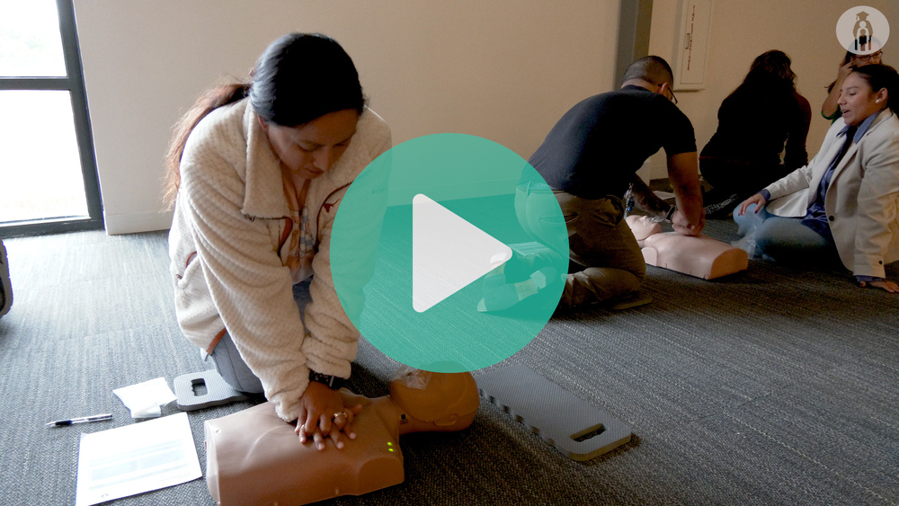 Round Rock ISD employee practicing chest compressions on CPR dummy
