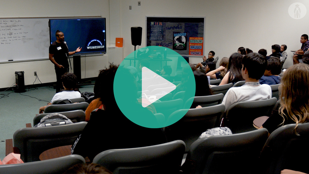 Picture of lecture hall with poetry slam artist talking to students.