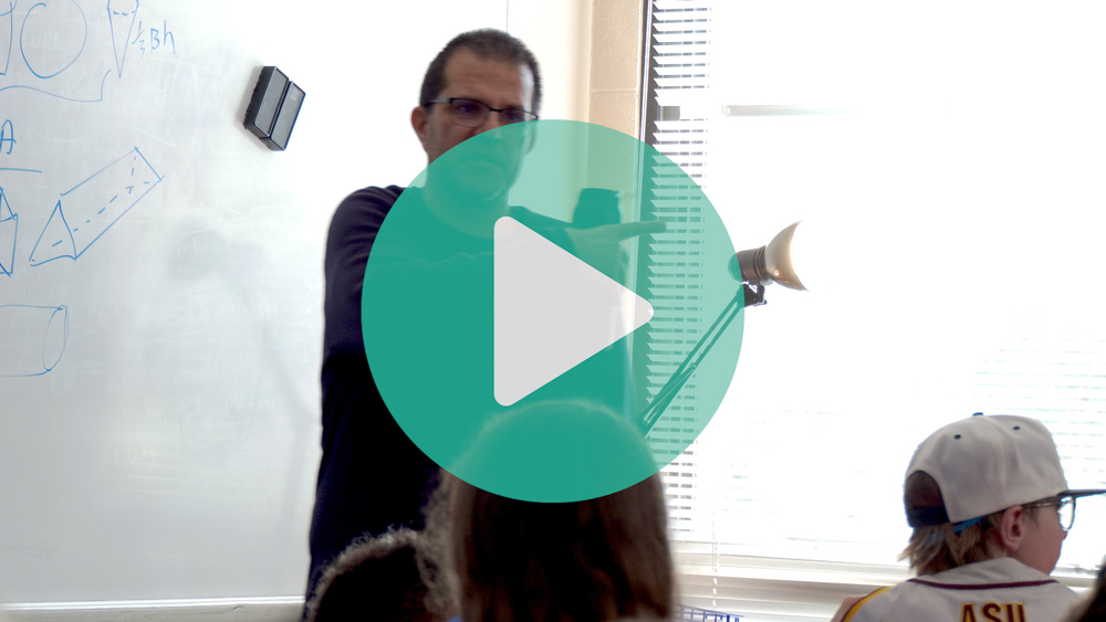 Picture of teacher, Robert Ohanian standing in front of his classroom.