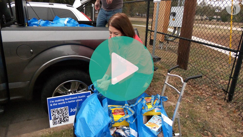 Picture of Round Rock ISD employee putting a bag full of groceries onto a loading cart.